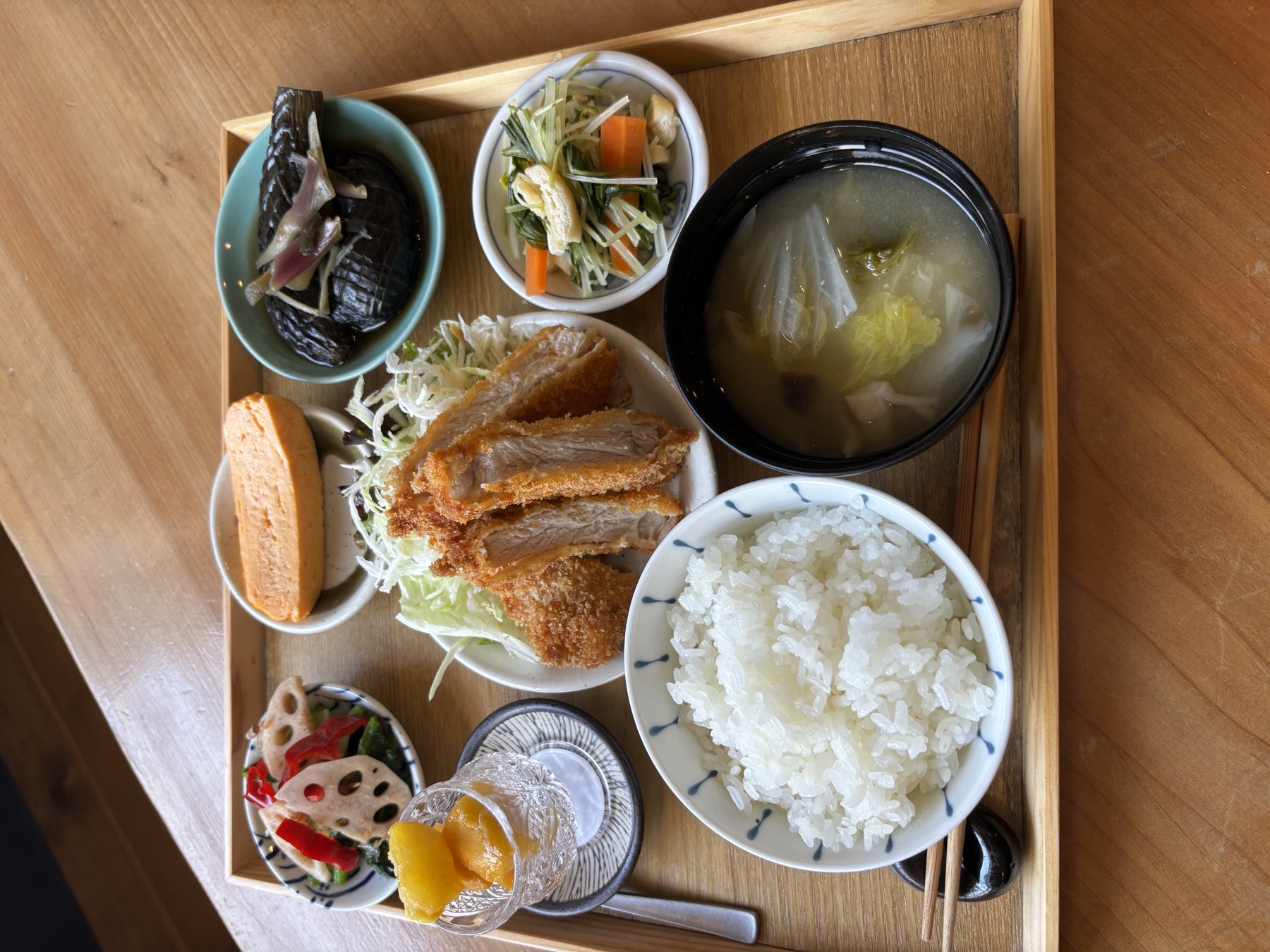 ごはん、味噌汁、主菜、小鉢を木の盆に並べたRoe's Kitchenの定食